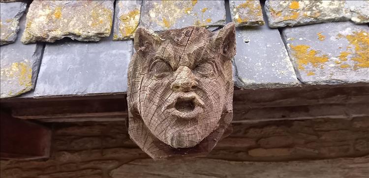 A wooden face carved into the wood of the roof