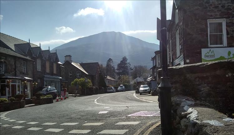 The village centre of Beddgelert with traditional welsh buildings and the towering Moel Hebog