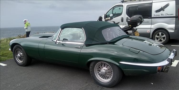A soft top British Racing Green Jaguar E-Type at the Lighthouse, Sharon is looking away out to sea