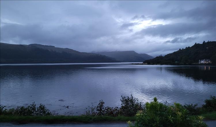 Darkening skies, heavy cloud and mist over the otherwise smooth waters of Loch Sunart