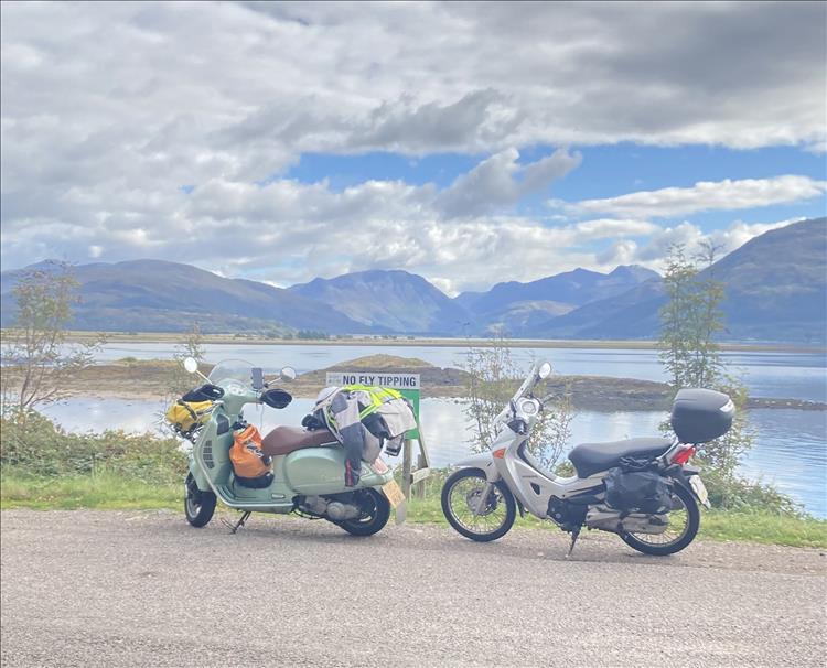 The 2 small motorcycles by a stunning loch in the Highlands