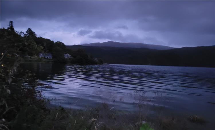 The waters have but the slightest of waves in the darkening skies, the loch is calm