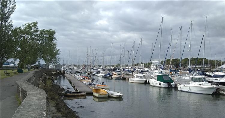 A selection of sailing boats and small yachts line the walkways of the marina