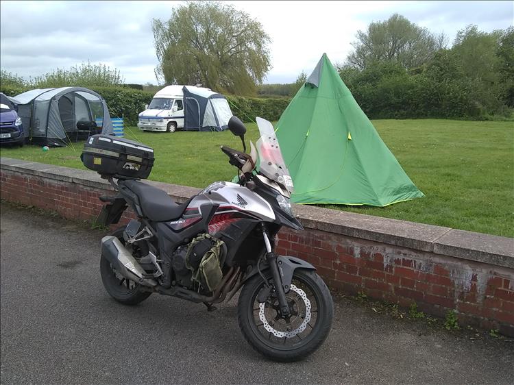 The bike and the teepee tent on a field behind a pub