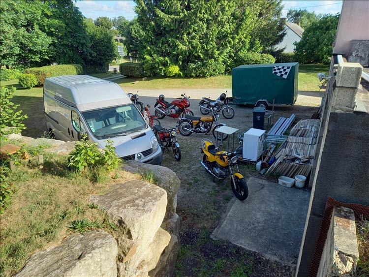 Looking down we see several motorcycles as well as a van and trailer in the large garden at Brian's house