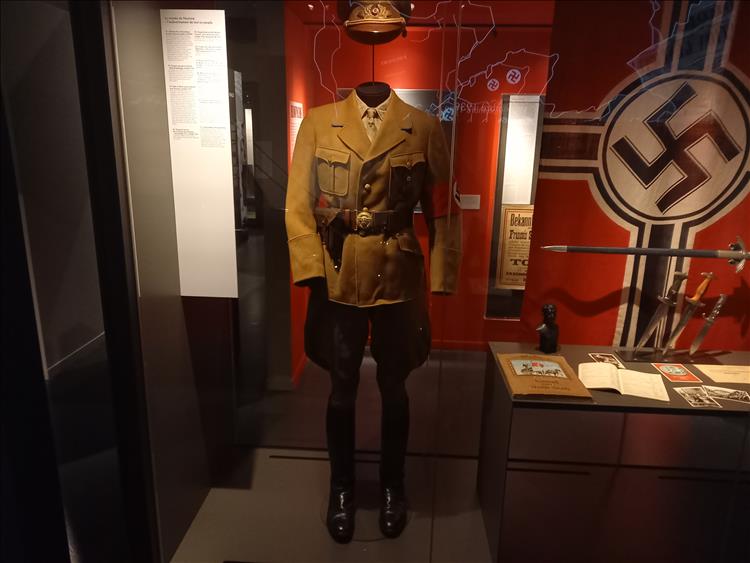 A display of a Nazi flag, uniform, sword and other war items