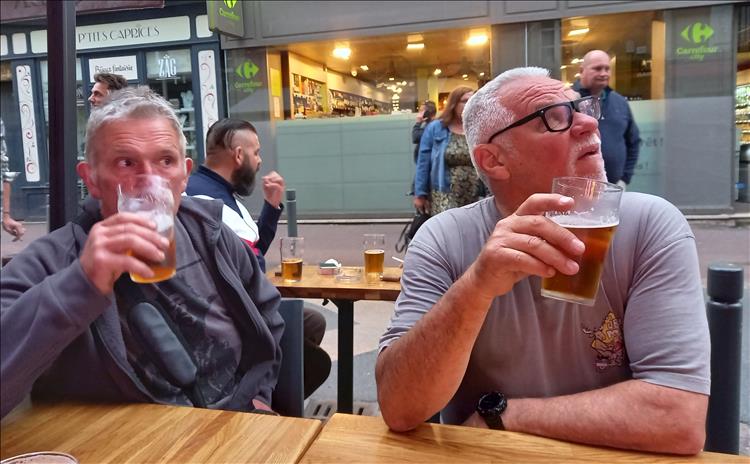 2 regular chaps sipping beer and looking about in the town centre