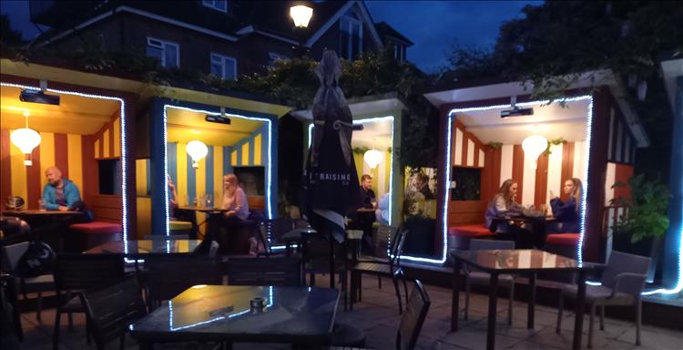 Booth lit with lights in all colours around a small square at the bar in Dorking
