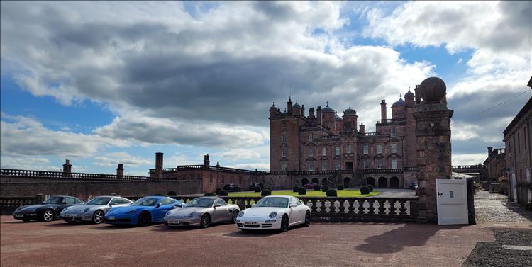 Five smart Porsches outside the grand ornate castle at Drumlanrig
