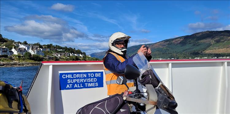Ren is taking pictures on the ferry in front of a sign stating children need to be supervised at all times