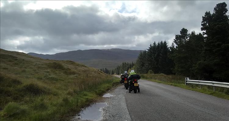 In a passing place we see the bikes against a dramatic and vast Highland backdrop