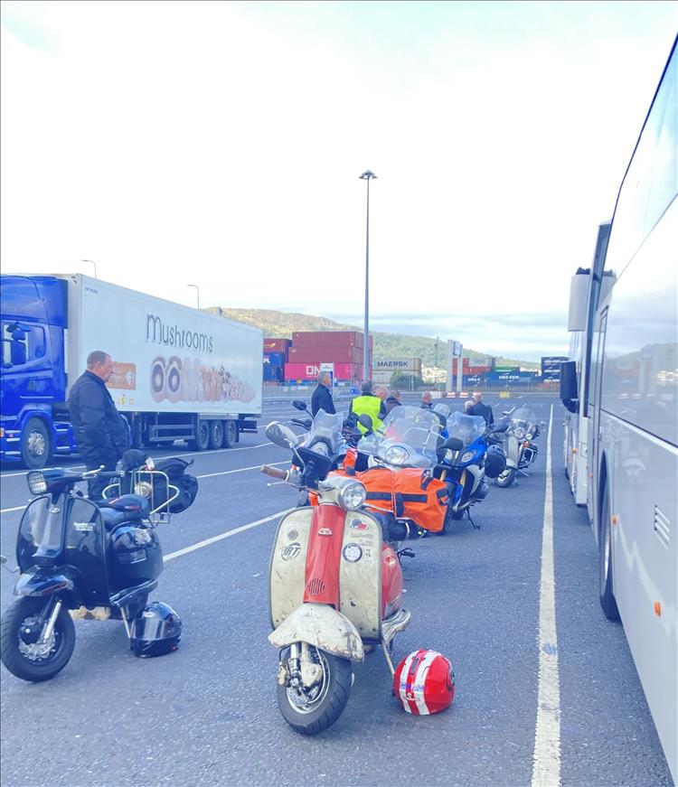 A line of scooters with camping gear in the queue at Belfast's Stena Terminal