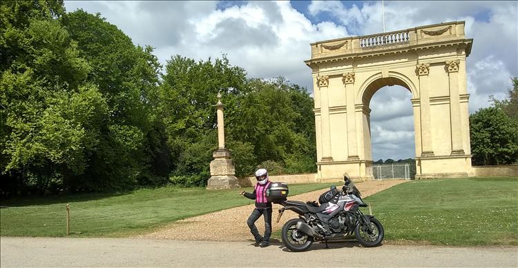 Sharon poses and pretends she's showing us the impressive archway to Stowe
