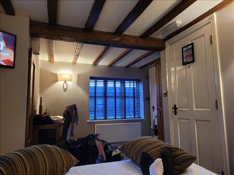 The bedroom is quite small with visible roof beams but otherwise crisp and modern