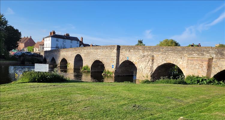The old stone bridge crosses the river with several short spans