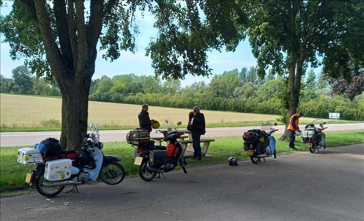 4 125cc motorcycle laden with camping and travel luggage by the side of a peaceful French road