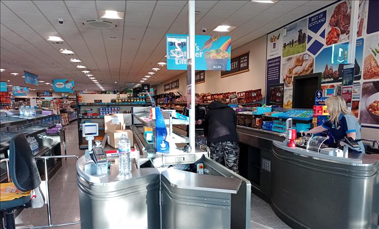 The inside of an Aldi with tills and shoppers