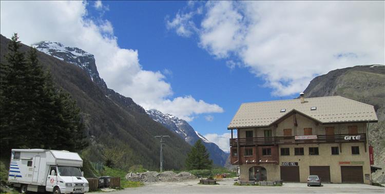 A broad dusty car park, a closed hotel and the towering mountains of the Alps