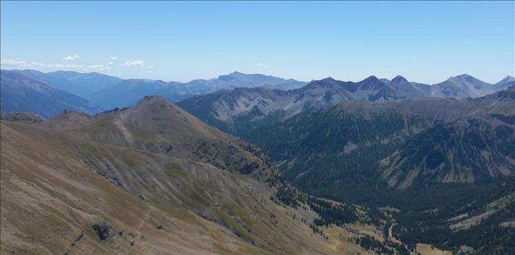 Stunning view across mountain tops of The Alps with sunshine and peaks