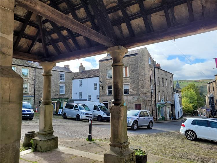 Looking out from under an ancient wooden market shelter is the village of Alston