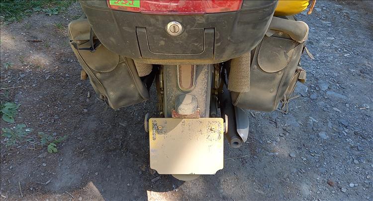 The numberplate and back of Bogger's Honda Cub is covered in light brown dirty and dust