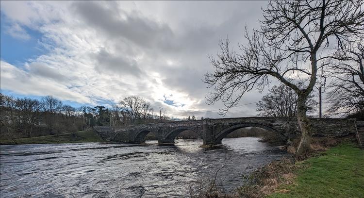 A 4 span stone arch bridge over a broad river, the River Dee
