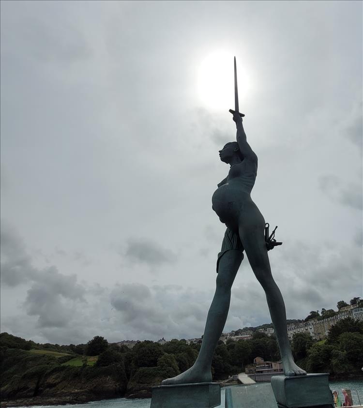 A massive statue set against the hazt sun at Ilfracombe Harbour