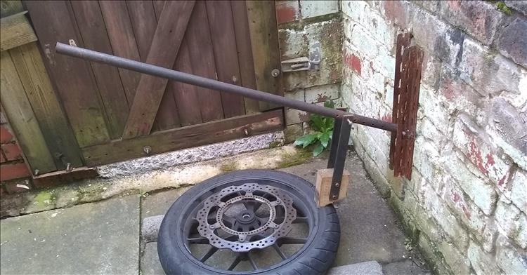 A long metal bar, slotted angle bolted to the wall and a wooden block make the home made bead breaker