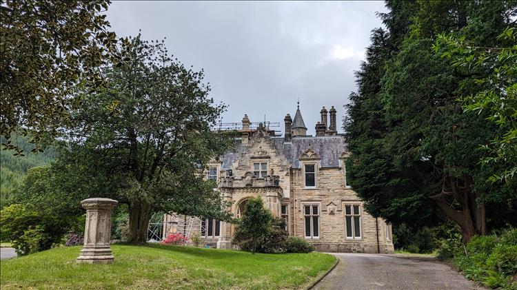 A large stone country house that needs repair and work is under way