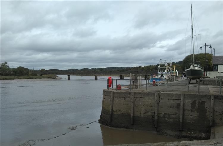 A stout harbour wall, a handful of boats, a river estuary and a bridge in Kirkcudbright