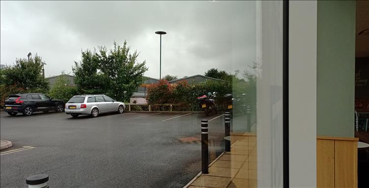 A regular car park seen through the window of the cafe, the bikes are visible