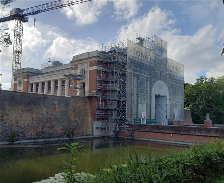 The large Menin Gate building with the front covered in Scaffold and a tower crane behind