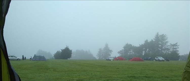 Looking out from the tent to the field with other camper's tents its misty and moist today