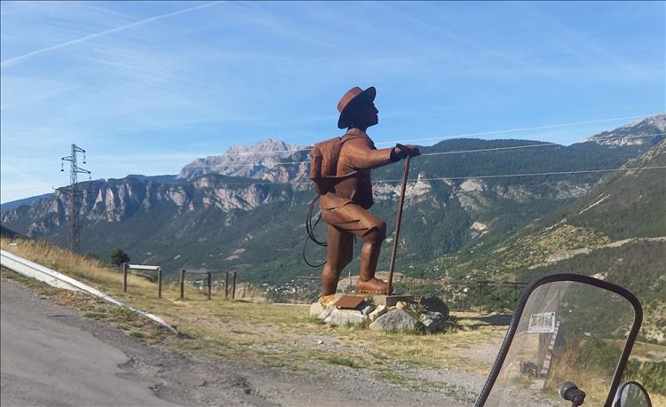 A very large statue of a mountaineering man by the road to Briancon