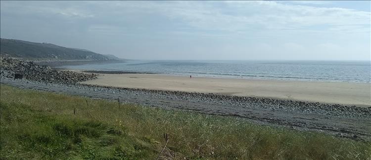 A wide open broad sandy beach with gentle hills and calm waters on the Galloway coast