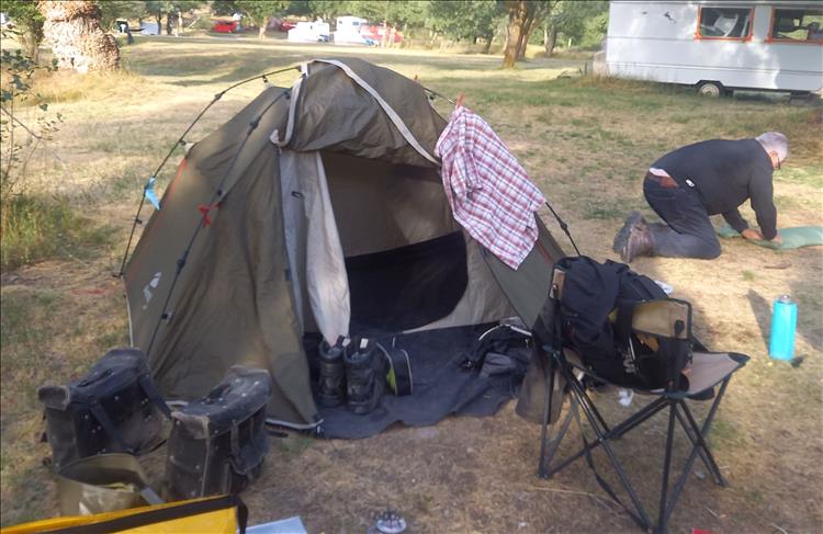 One of Bogger's friends is rolling up his ground mat as they pack up to leave the campsite