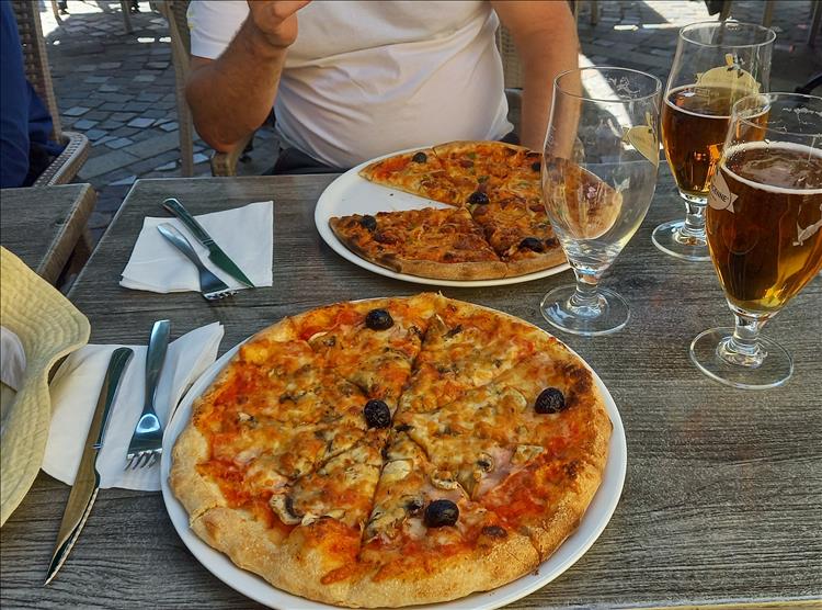 Beers and pizzas on the table in the evening sun