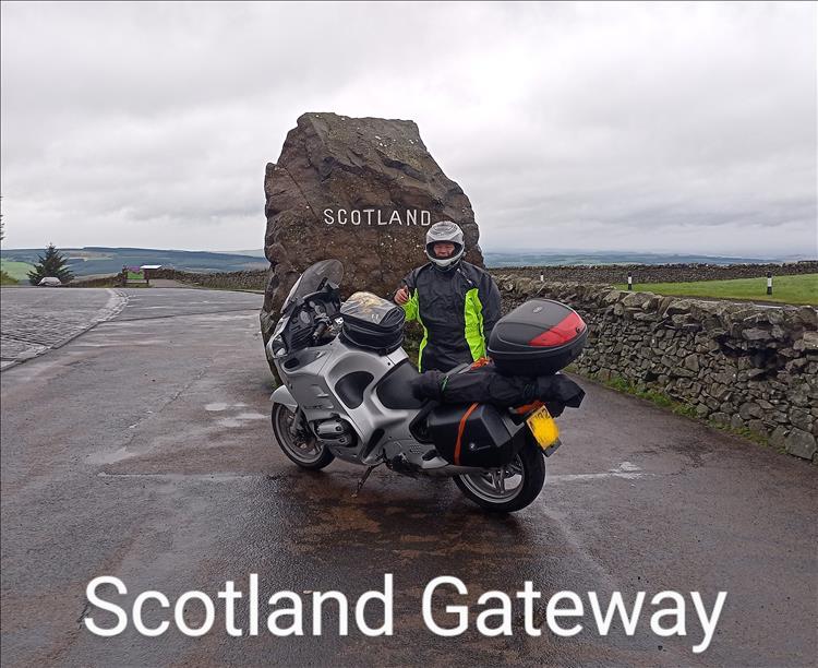 ROD and his bike by a large rock with "SCOTLAND" written on it