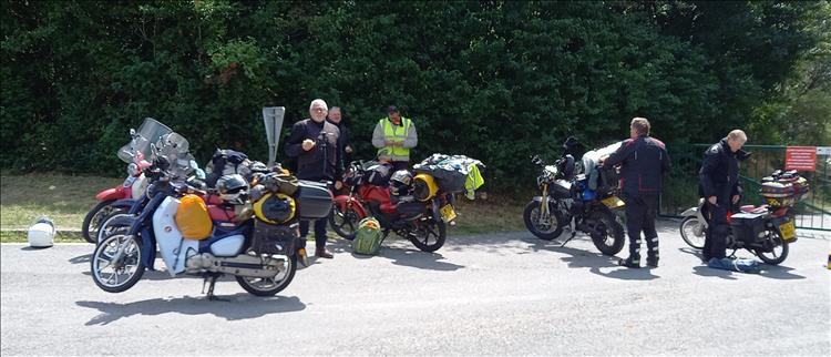 6 bikes all around 125cc, 5 riders in a car park sunshine through France