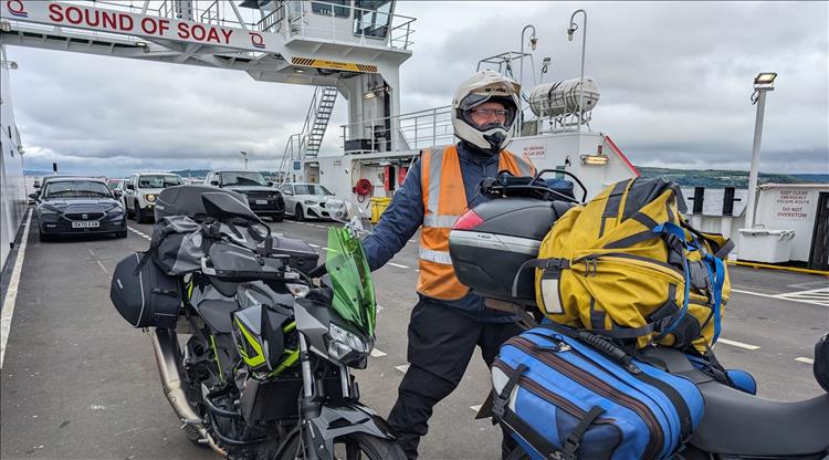 Ren stands proudly behind the bikes on a ferry deck crossing the Clyde estuary