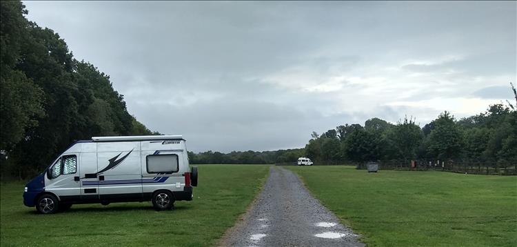 A vast empty field at the campsite with just 2 campervans in it