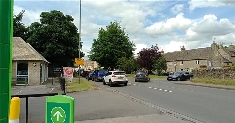 A line of regular cars, the edge of a petrol station and sunshine in Stow on the wold