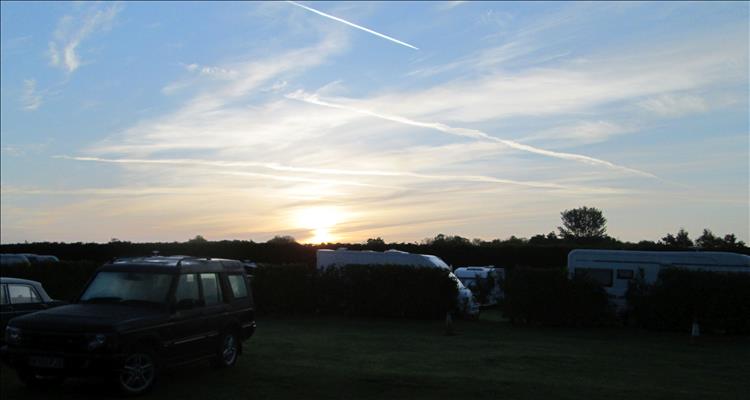 Big skies with con trails and the setting sun in Lincolnshire