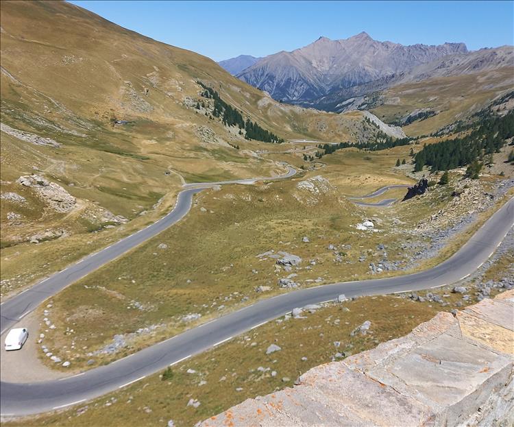 Looking down the mountainside we see a gnarly twisting road climbing steeply