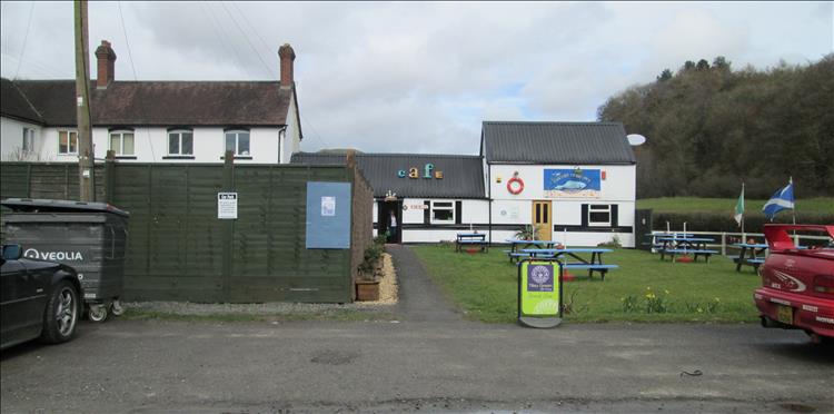 A white painted building with the Lazy Trout Cafe sign