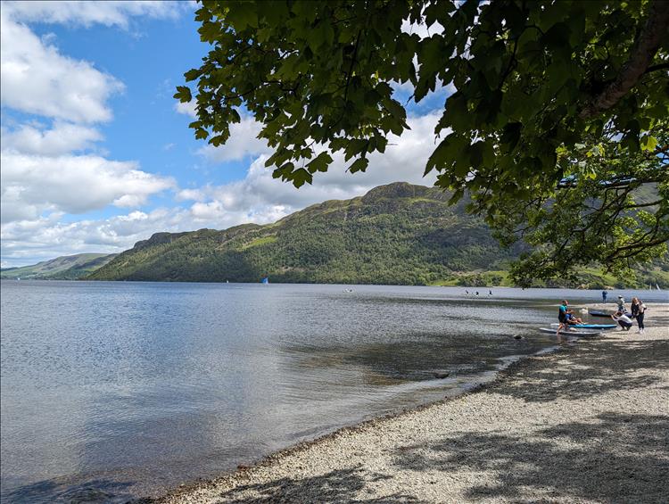 The Ullswater lake, canoeists, treelined hills and sunshine