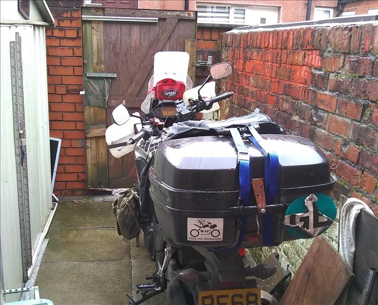 Ren's bike in the scruffy back yard, in the rain and with a light luggage load