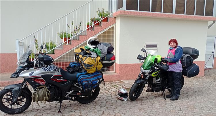 The bikes with all their luggage and Sharon wearing waterproofs and smiling