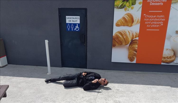 One of Bogger's motorcycling friends rolling around on the floor outside a public toilet