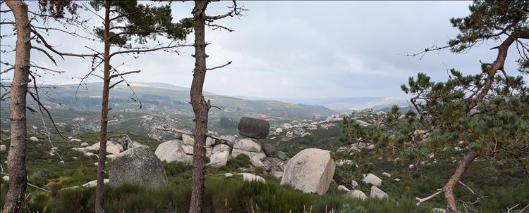 Looking out over the valley are large boulders the size of houses, some of the stacked up